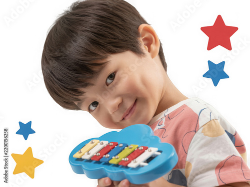Joyful young boy playing with a colorful musical toy with stars floating around him