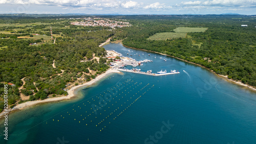 Aerial View of Marina and Beach Along Forested Coastline With Boats and Village in Summer, Vabriga, Croatia