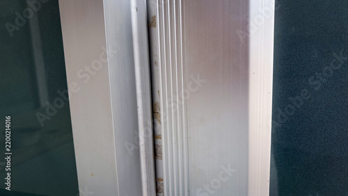 Close up of silver aluminum metal profile frame on glass sliding door with industrial texture