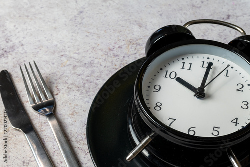 Fotografie Intermittent Fasting Concept With Alarm Clock And Cutlery