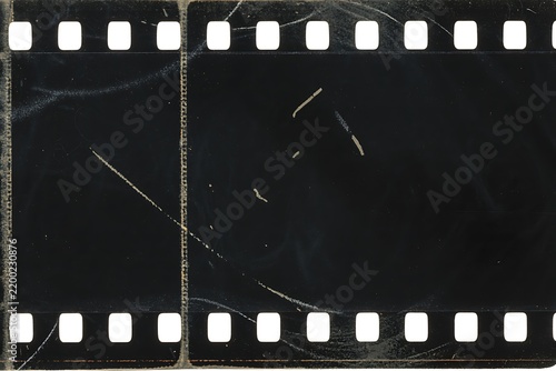 Film negative strip features heavy scratches and dark tones.