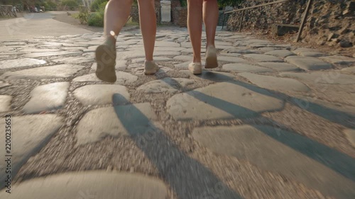 Two People Walking Across Ancient Roman Paving Stones at Sunset
