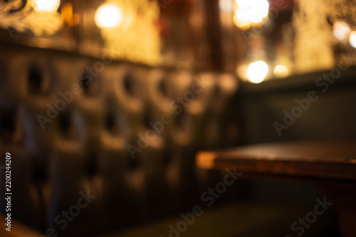 London, England, United Kingdom, August 14, 2026. Defocused interior view of a dark leather pub booth and table.