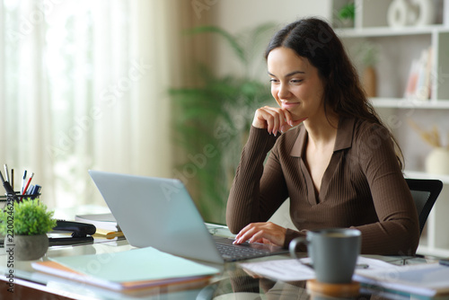 Satisfied telecommuter checking laptop working online at home