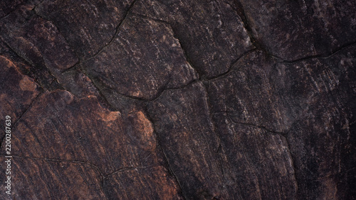 Close-up photo of natural rock surface with cracks and layered tones. Perfect for geology, texture, design, and creative background themes.