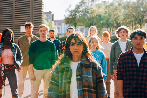 Young woman leads a crowd of protesters walking through the city