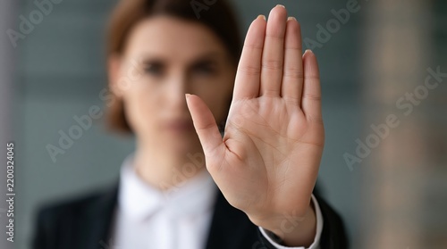 Woman in suit showing hand palm gesture of stop and refusal as a professional barrier of assertive boundary work