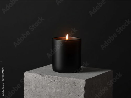 Lit black candle jar on concrete pedestal