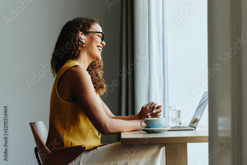 Happy african woman enjoys a video call with a client from her home office