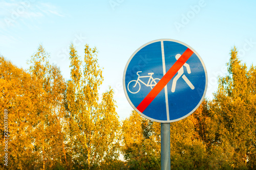 Road sign No Pedestrians and Bicycles on this part of the road, closeup of prohibitive sign on a metal pole on the background of autumn trees
