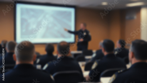 Police instructor conducting a tactical lesson in a classroom, out-of-focus shot