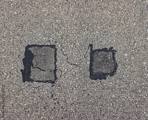 Asphalt with patched holes, Fresh patch hole asphalt road. New asphalt patch laid on repaired road. Old asphalt road pothole pit. Fresh patch large hole on highway. Roadwork.
