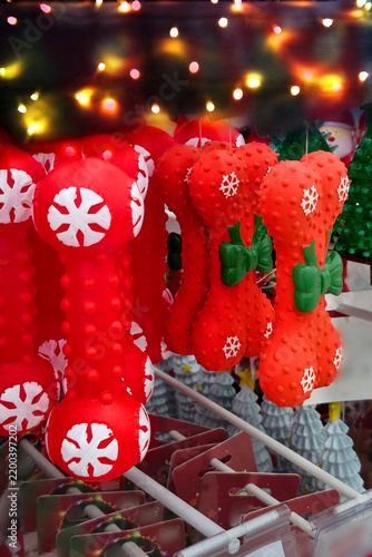 Foto Red dog chew toys shaped like bone with white snowflake patterns, holiday pet gi