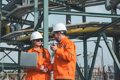 Team of petroleum engineers is discussing matters while working at a petroleum refinery.