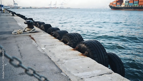 Industrial port on waterfront with tire barrier and dock infrastructure