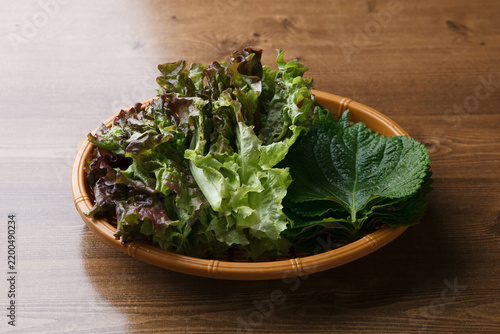 Fresh lettuce and perilla leaves in woven basket for Korean barbecue wraps