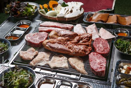 Obraz na plátně Various fresh meat cuts arranged on charcoal grill table for Korean barbecue