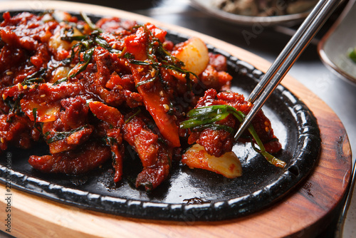 Spicy stir fried pork with chives sizzling on cast iron plate