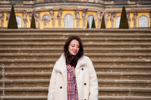 Girl tourist walking stairs. Sightseeing and landmark. Stylish woman in fall coat at palace stairs. Woman stand at stairs to palace. Girl casual style outdoor. Touristic and travel destination