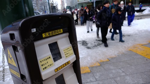 雪道のスリップ事故を防ぐ街頭のすべり止め砂箱と往来する人々 ,北海道 札幌市