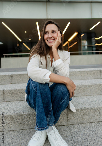 Картината върху платно Young woman smiling sitting on urban stairs thinking