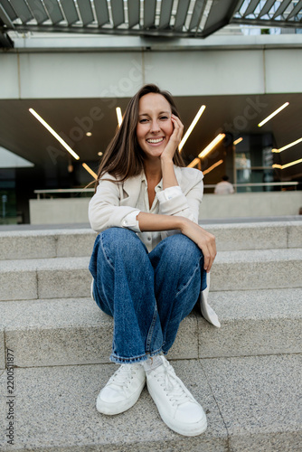 Фотография Young woman smiling sitting on urban steps