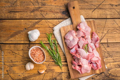 Fotografie Fresh poultry offal arranged on a natural wood surface, salt and garlic add detail, rustic backdrop enhances texture