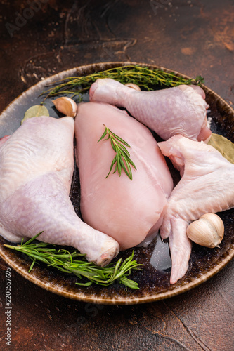 Konstfotografi The promise of a perfect roast: prime raw poultry cuts rest with fragrant rosemary, thyme, and garlic on a deep, earthen plate, awaiting their culinary transformation