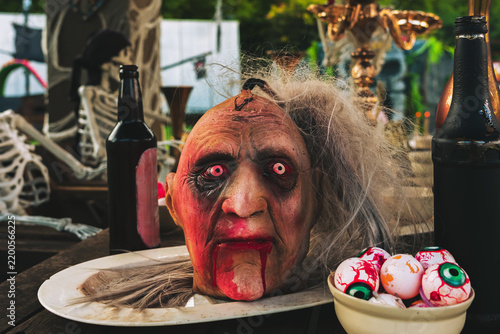 Canvastavla Scary severed witch or zombie head prop on plate with bloody eyeballs prop and potion bottles on wooden table for Halloween display