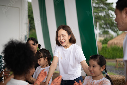 A joyful gathering of children and adults, engaging in fun activities outdoors, showcasing the joy of community bonding and shared experiences.
