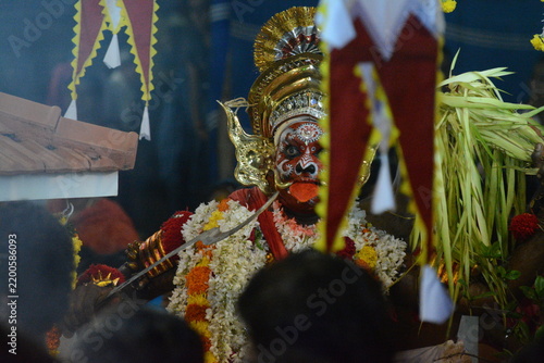 Obraz na plátně Traditional Theyyam performer in elaborate headdress and floral garlands 2
