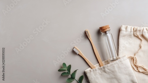 Bamboo toothbrushes and reusable glass bottle arranged on a neutral background, sustainable bathroom essentials, zero waste oral care and eco lifestyle flat lay