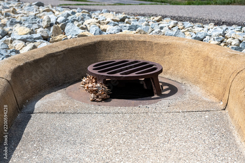 Raised Cast Iron Beehive Drain Grate on Concrete Curbing. Infrastructure Background