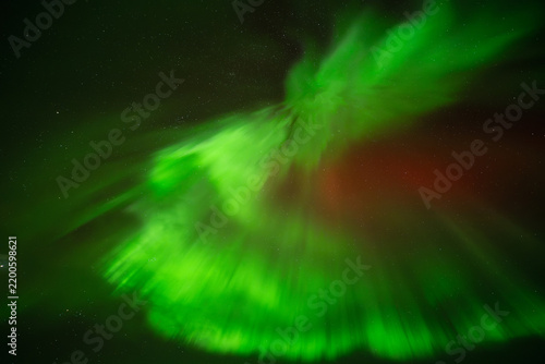 View of the vibrant green Aurora Borealis illuminating the night sky over Iceland.