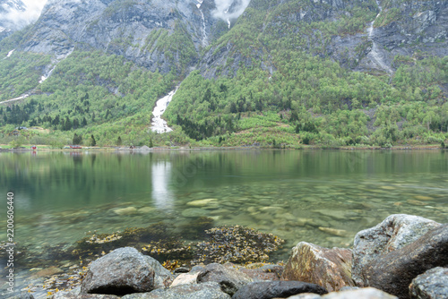 Waterfall flowing into lake Norway fjord landscape