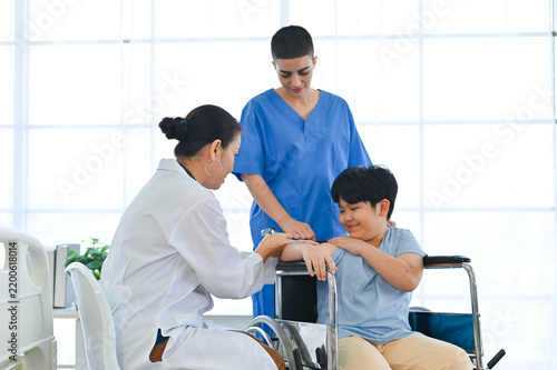 Картината върху платно A compassionate healthcare worker interacts with a young patient in a wheelchair, showcasing the importance of empathy and patient care in medicine