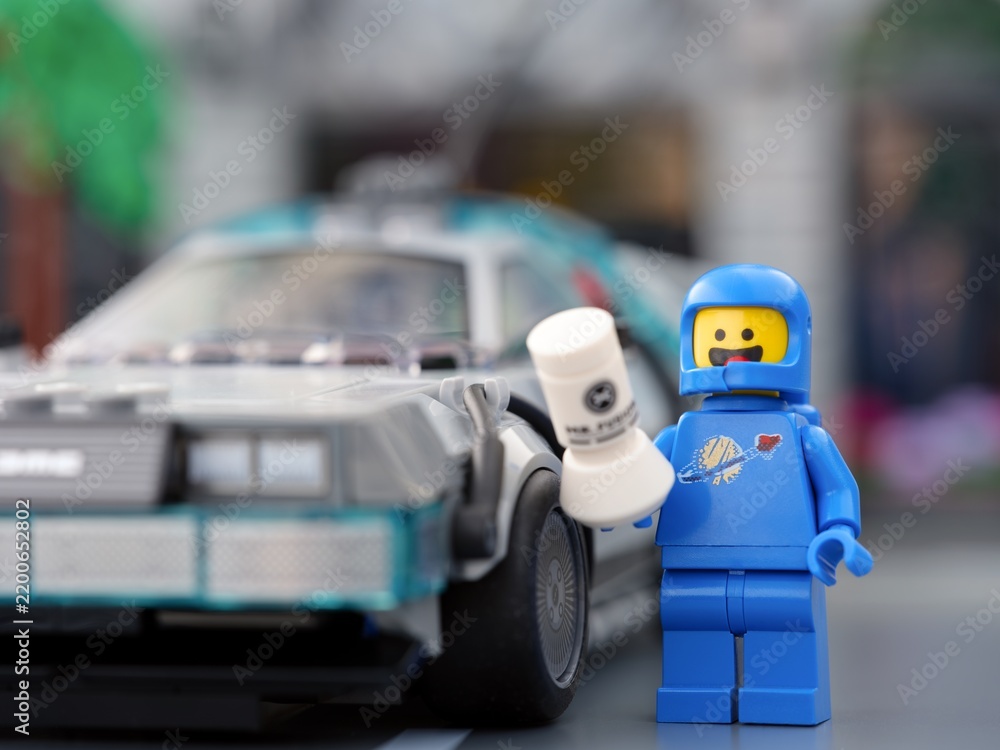 Obraz premium Tambov, Russian Federation - September 17, 2026 Blue Lego spaceman minifigure holding a Mr. Fusion generator next to the DeLorean time machine.