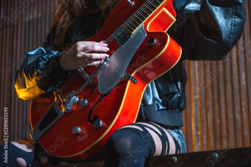 Фотография Macro shot of unrecognizable guitarist hand holding strumming guitar strings, ca