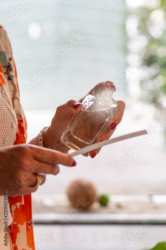 Bild auf Leinwand Person spraying perfume on a paper blotter strip for an olfactory fragrance test