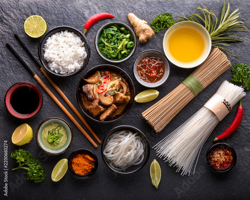 Overhead view of an artistic arrangement of Asian food ingredients on a stone surface