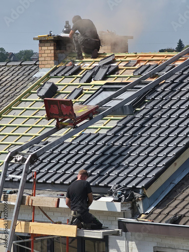 Ouvriers qui rénovent la toiture d’une maison pour isolation et remplacement des tuiles