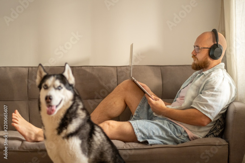 Quadro su tela Close portrait of husky muzzle with owner working in background, attention asked exactly during busiest hour, scene for pet brand