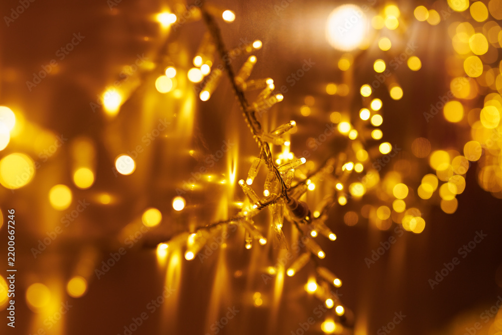 Obraz premium Golden Christmas fairy lights glowing with warm bokeh background