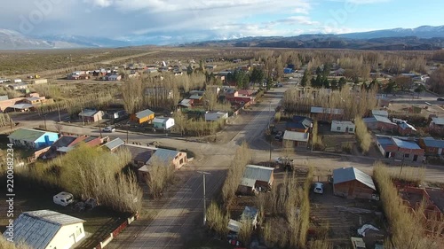 4K drone aerial view over Lago Posadas village in Santa Cruz, Argentina, revealing homes surrounded by rugged Patagonian landscapes, arid terrain and remote wilderness scenery.