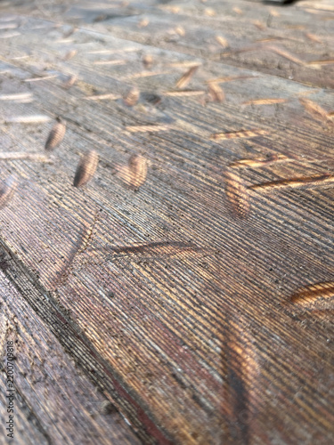 Obraz na płótnie Vertical eye level shot of a damaged brown wooden surface with notches, cuts, an