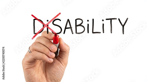 A hand uses a red marker to cross out the prefix dis from the word disability on a white background