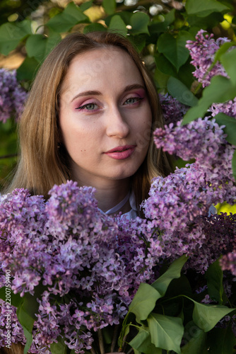 Artistic spring portrait with lilac blossoms and romantic female elegance