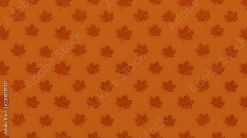 Orange maple leaf pattern on dark ginger background creates warm autumn seasonal texture.