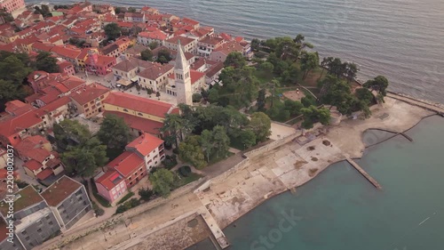 Aerial orbit view of old town bell tower seaside promenade and coast in Novigrad Istria Croatia