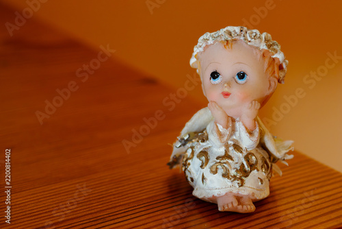 Fotografie Small angel figurine with a sweet face, light blue eyes, and delicate wings, bri